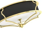 Złota lampa sufitowa Stesso Gold Nero S z czarnym abażurem, o okrągłym kształcie. Widoczna metalowa konstrukcja w złotym kolorze z detalami dekoracyjnymi. Lampa montowana sufitowo, z białym kloszem w centralnej części.