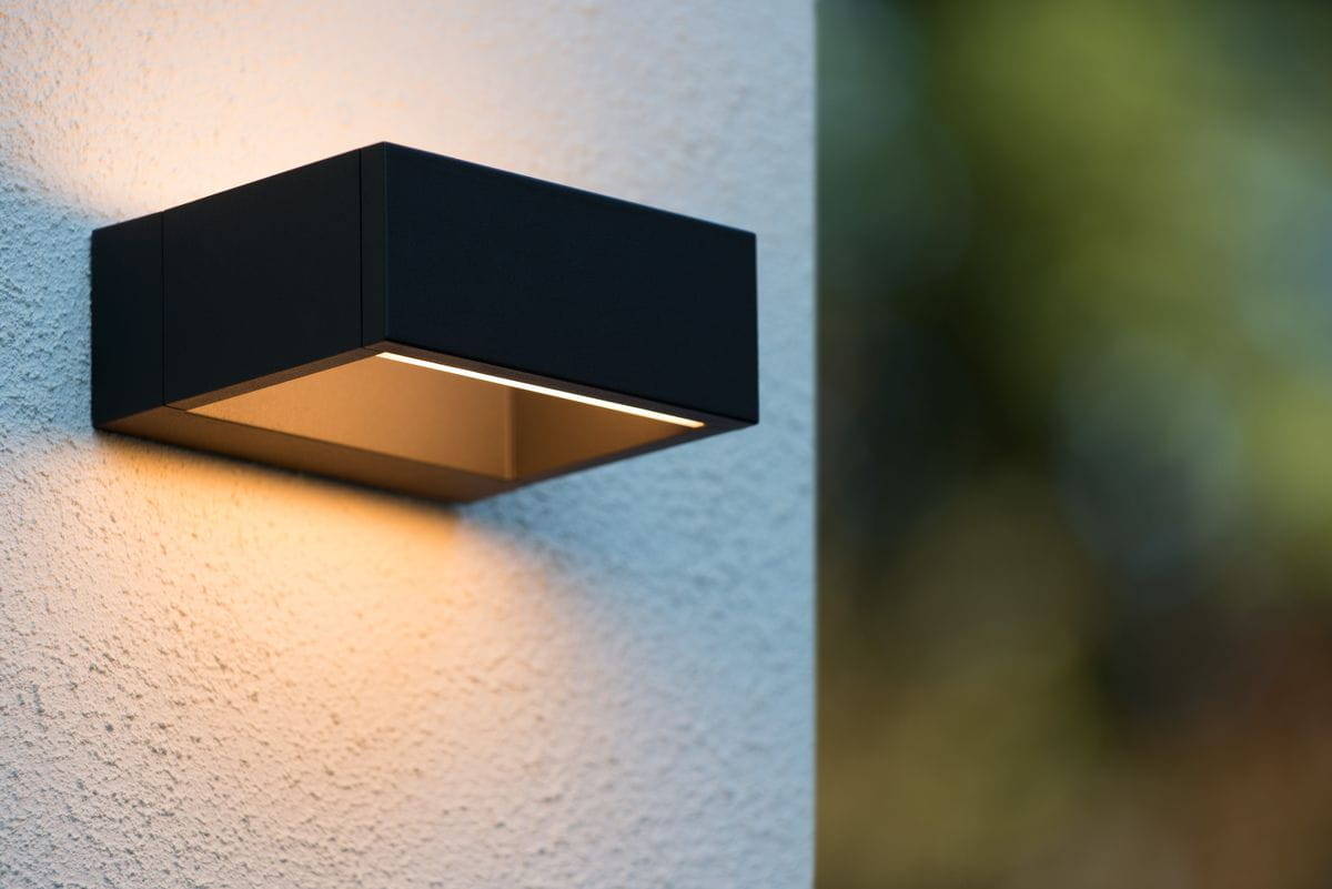 Goa LED kinkiet elewacyjny w kolorze czarnym, prostokątny, zamontowany na białej ścianie. Emituje ciepłe światło w dół, z widoczną metalową obudową i minimalistycznym designem. Idealny do oświetlenia zewnętrznego.