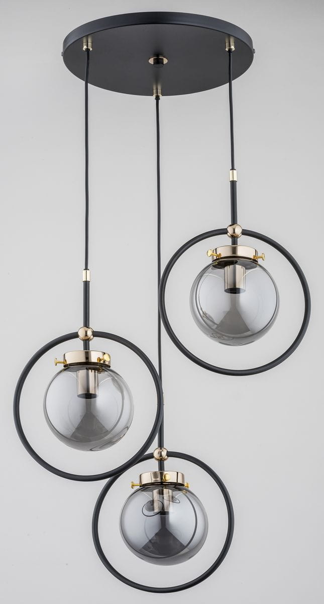 Akira lampa wisząca 3-punktowa w kolorze czarnym i złotym, z trzema szklanymi kloszami w formie kul, zawieszona na czarnych linkach. Klosze osadzone w złotych oprawach, z okrągłymi metalowymi elementami. Całość montowana do sufitu.