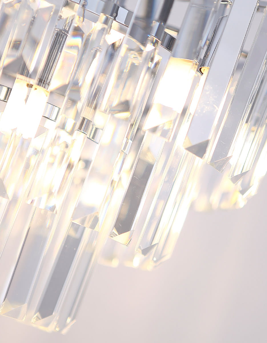 Lampa wisząca Monaco z 15 punktami świetlnymi, wykonana z przezroczystego szkła, z kryształowymi elementami w formie prostokątnych pryzmatów. Ujęcie zbliżeniowe, ukazujące detale struktury i refleksy świetlne.