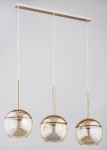 Lampa wisząca 3-punktowa Volda w kolorze złotym. Składa się z trzech okrągłych kloszy w przezroczystym szkłach, zawieszonych na cienkich, białych linkach. Klosze mają metalowe, złote elementy u góry. Montaż sufitowy na prostokątnej listwie.