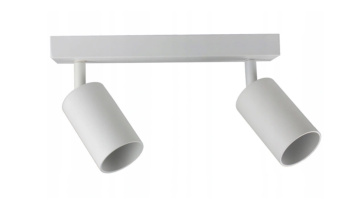 Biała lampa sufitowa typu spot z dwoma cylindrycznymi kloszami, zamontowana na prostokątnej podstawie. Klosze są skierowane w różne strony, co umożliwia regulację kierunku światła. Produkt wisi poziomo na gładkiej powierzchni.