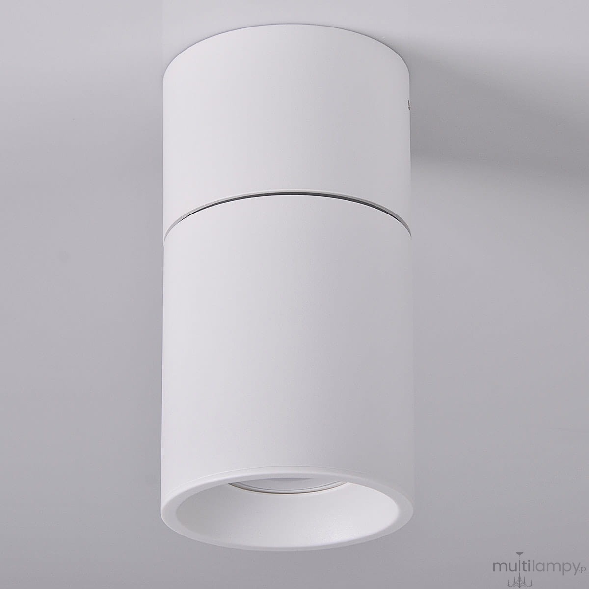 Biała, okrągła lampa sufitowa (spot) Astra, zamontowana na suficie, z widocznym kloszem w formie cylindra. Lampa ma prosty, minimalistyczny design, z gładką matową powierzchnią i otwartym dołem, co umożliwia skierowanie światła w wybraną stronę.