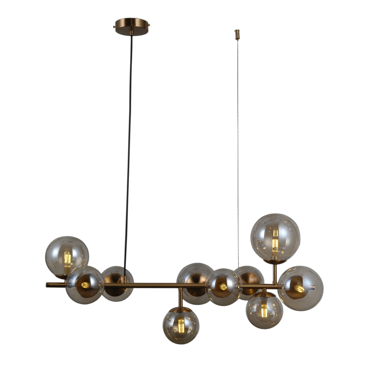 Lampa wisząca Frontera 10-punktowa w kolorze mosiądzu, z przezroczystymi szklanymi kloszami w różnych rozmiarach. Ujęcie z boku pokazuje jej nowoczesny design i unikalny układ, zawieszona na czarnym przewodzie.