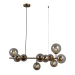 Lampa wisząca Frontera 10-punktowa w kolorze mosiądzu, z przezroczystymi szklanymi kloszami w różnych rozmiarach. Ujęcie z boku pokazuje jej nowoczesny design i unikalny układ, zawieszona na czarnym przewodzie.