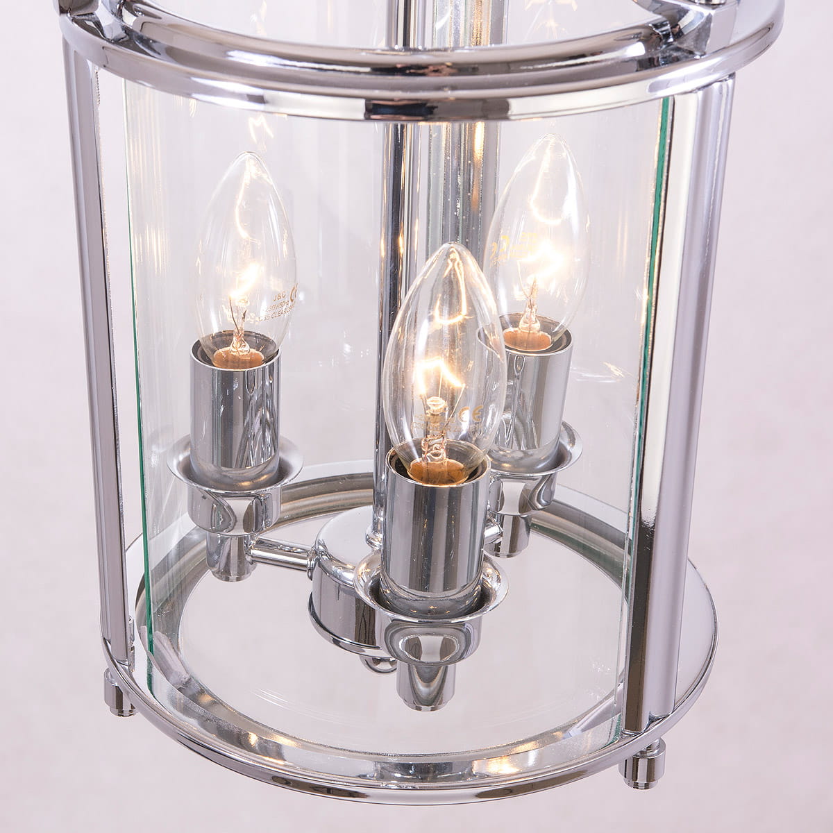 Lampa wisząca New York 3-punktowa P03427CH z chromowanym wykończeniem i przezroczystymi kloszami. Zawiera trzy świecznikowe żarówki w metalowych oprawach. Produkt umieszczony w centralnej części, z widocznymi detalami.