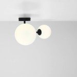 Czarna lampa sufitowa 2-punktowa Pure, z dwiema białymi, okrągłymi kloszami na metalowej podstawie. Ujęcie z dołu, ukazujące oba klosze w różnych rozmiarach, zamontowane na gładkim, białym suficie.