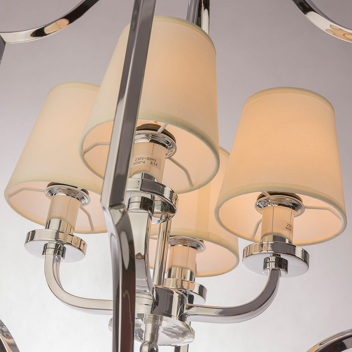 Lampa wisząca New York 4-punktowa P04380WH w kolorze chromu z czterema kloszami w odcieniu kremowym. Ujęcie z bliska, pokazujące detale mocowania i kształt kloszy. Metalowe elementy oraz elegancki design.