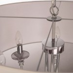 Lampa wisząca Abu Dhabi 6-punktowa w chromie, z okrągłym kloszem. Widoczne chromowane mocowanie i sześć miejsc na żarówki w kształcie łzy. Klosz w jasnym kolorze, z detalami w chromie. Ujęcie z góry, zbliżenie na detale konstrukcyjne.