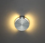 Oprawa schodowa Lesel LED 004 w kształcie okrągłym, wykonana z matowego metalu w kolorze srebrnym. Zamontowana na suficie, emituje ciepłe światło wokół krawędzi, tworząc delikatny efekt oświetlenia.