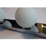 Brazos kinkiet 3-punktowy w kolorze chromu, z trzema matowymi kulistymi kloszami. Kinkiet zamontowany na prostokątnej, lustrzanej podstawie, z widocznymi mocowaniami. Idealny do nowoczesnych wnętrz.