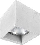 Lampa sufitowa Bold M 1-punktowa w kształcie sześcianu, wykonana z szarego betonu. W środku znajduje się reflektor z metalową osłoną. Produkt zamontowany na suficie, widoczny z boku, z wyraźnym detalem okrągłej żarówki.