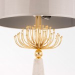 Lampa stołowa Cartagena 2-punktowa z metalową podstawą w kolorze złotym i marmurowym piedestale. Okrągły, szary klosz na górze, z dekoracyjnymi, zaokrąglonymi ramionami, które przypominają kwiat. Produkt w pozycji stojącej.