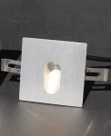 Oprawa schodowa Lesel LED 001 L w kolorze srebrnym, kwadratowa, z wycięciem na LED w centrum. Widać metalowe mocowania po bokach. Produkt leży na ciemnym tle, co podkreśla jego kształt i teksturę.