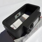 Kinkiet elewacyjny Muno LED 1-punktowy w kolorze czarnym, prostokątny kształt, widoczne otwory montażowe oraz elementy do podłączenia. Zdjęcie ukazuje produkt z góry, na tle opakowania.