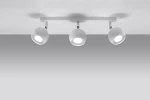 Biała lampa sufitowa Oculare z trzema punktami świetlnymi, zamocowana na prostokątnej, białej podstawie. Każdy reflektor ma okrągły kształt i emituje jasne światło. Produkt widoczny z góry, na jednolitym tle.