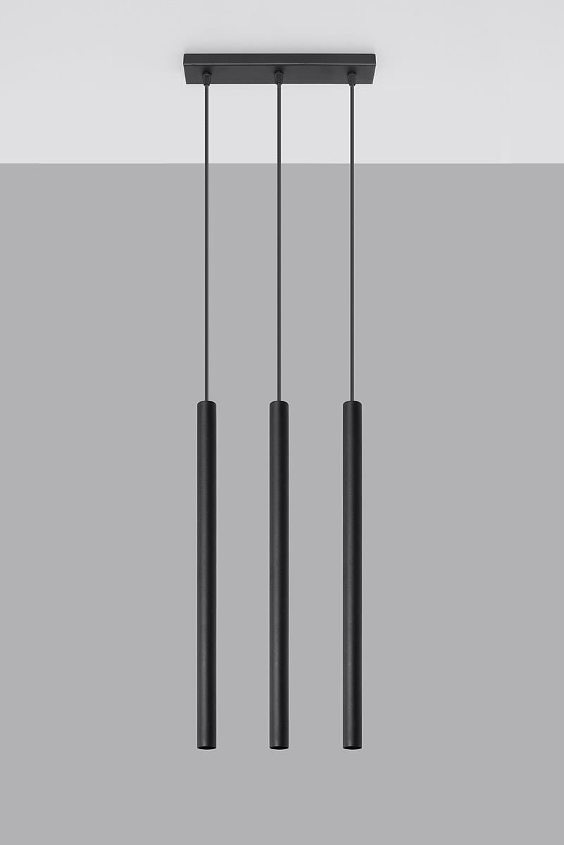 Trójpunktowa lampa wisząca Pastelo w kolorze czarnym, składająca się z trzech smukłych, cylindrycznych kloszy zwisających na cienkich kablach. Lampa zamontowana na prostokątnej podstawie sufitowej. Tło w odcieniu szarości.