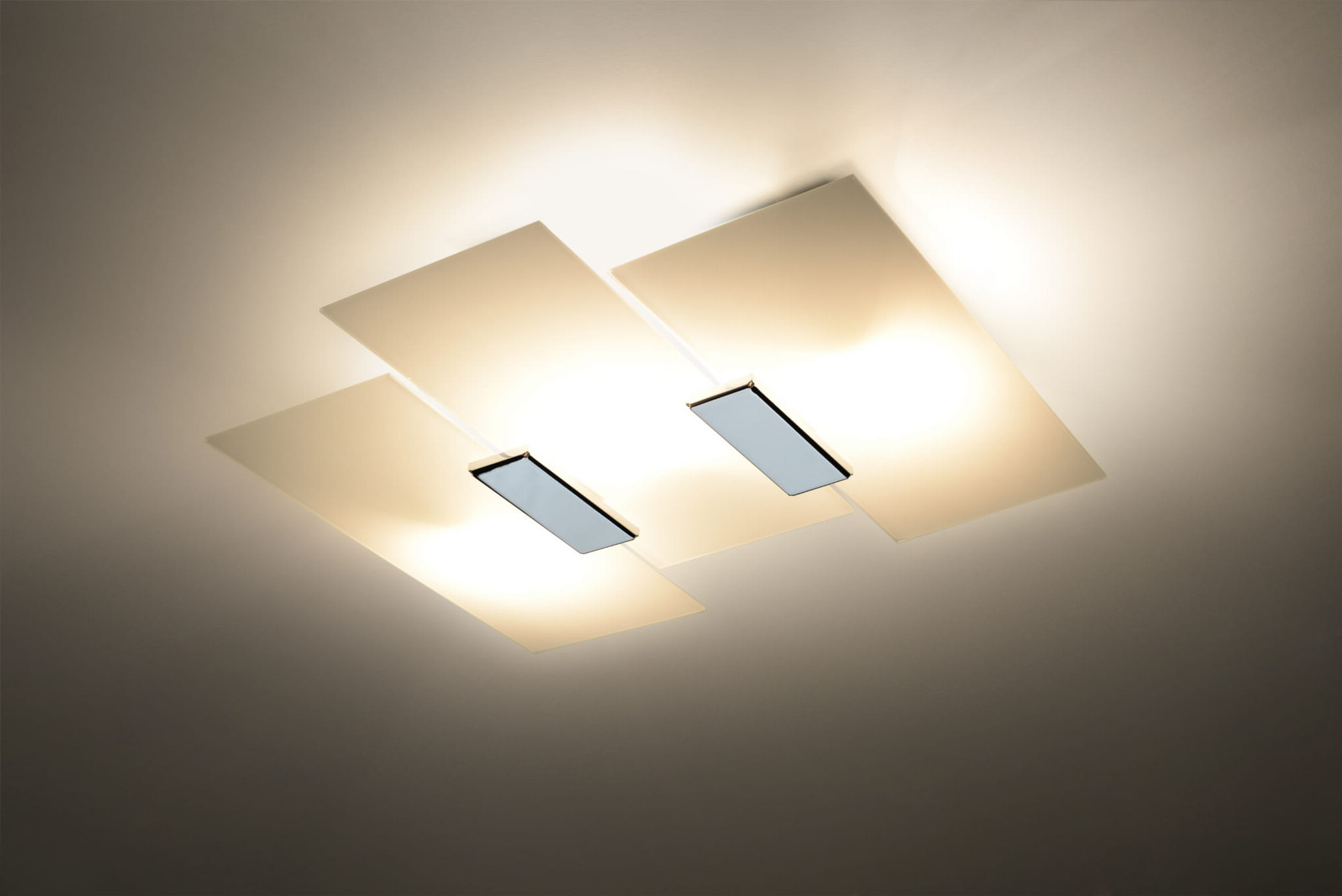 Lampa sufitowa Fabiano 3-punktowa SL.0198 z białymi, prostokątnymi kloszami i metalowymi detalami. Ujęcie z góry, ukazujące równomierne rozłożenie światła. Klosze emitują ciepłe światło, montowane na suficie.
