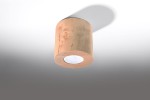 Lampa sufitowa Orbis Drewno 1-punktowa SL.0492 w kształcie cylindrycznym, wykonana z jasnego drewna. Wyposażona w okrągły otwór na źródło światła, zamontowana pod kątem, rzucająca cień na ścianę. Tło w odcieniach szarości.