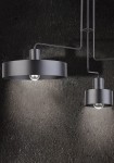 Czarna lampa sufitowa Vasco 3-punktowa z okrągłymi kloszami. Ujęcie z boku, z widocznymi dwoma kloszami: większym i mniejszym. Lampa zawieszona na cienkich przewodach, umieszczona na tle ciemnej, teksturowanej ściany.